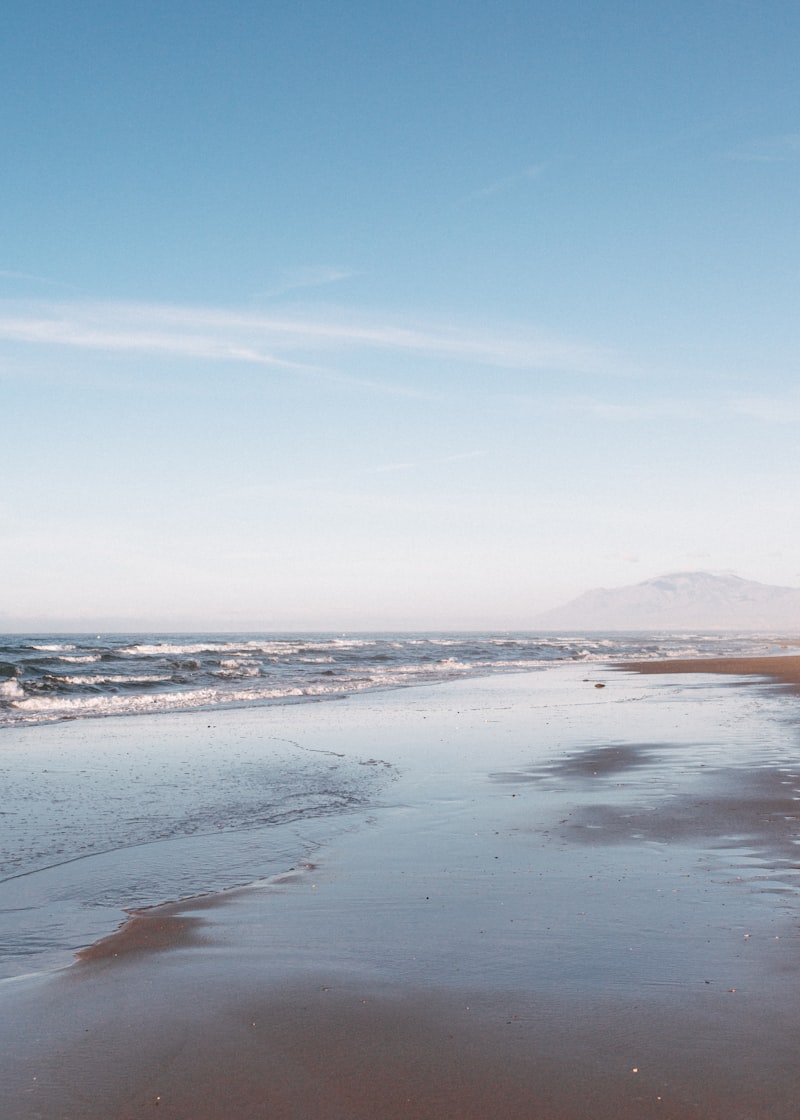 A sandy beach with waves coming in to shore