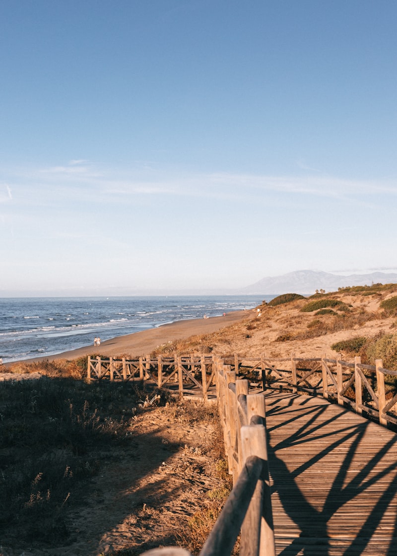 A wooden walkway leading to the beach on a sunny day